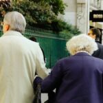 Älteres Paar spaziert Arm in Arm durch die Stadt