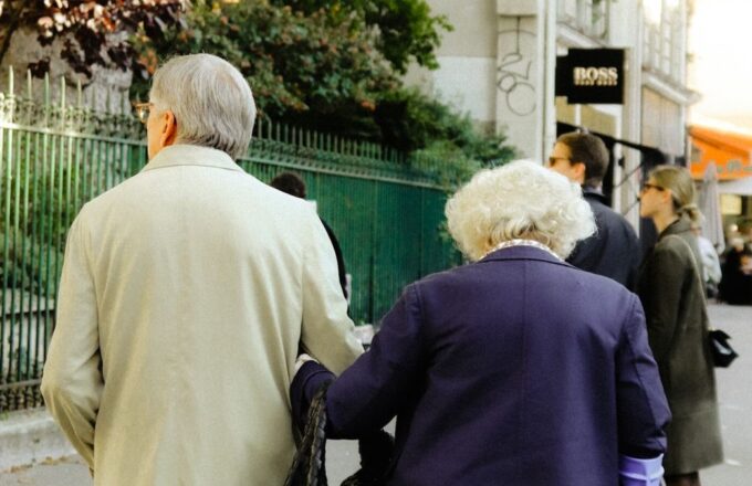 Älteres Paar spaziert Arm in Arm durch die Stadt
