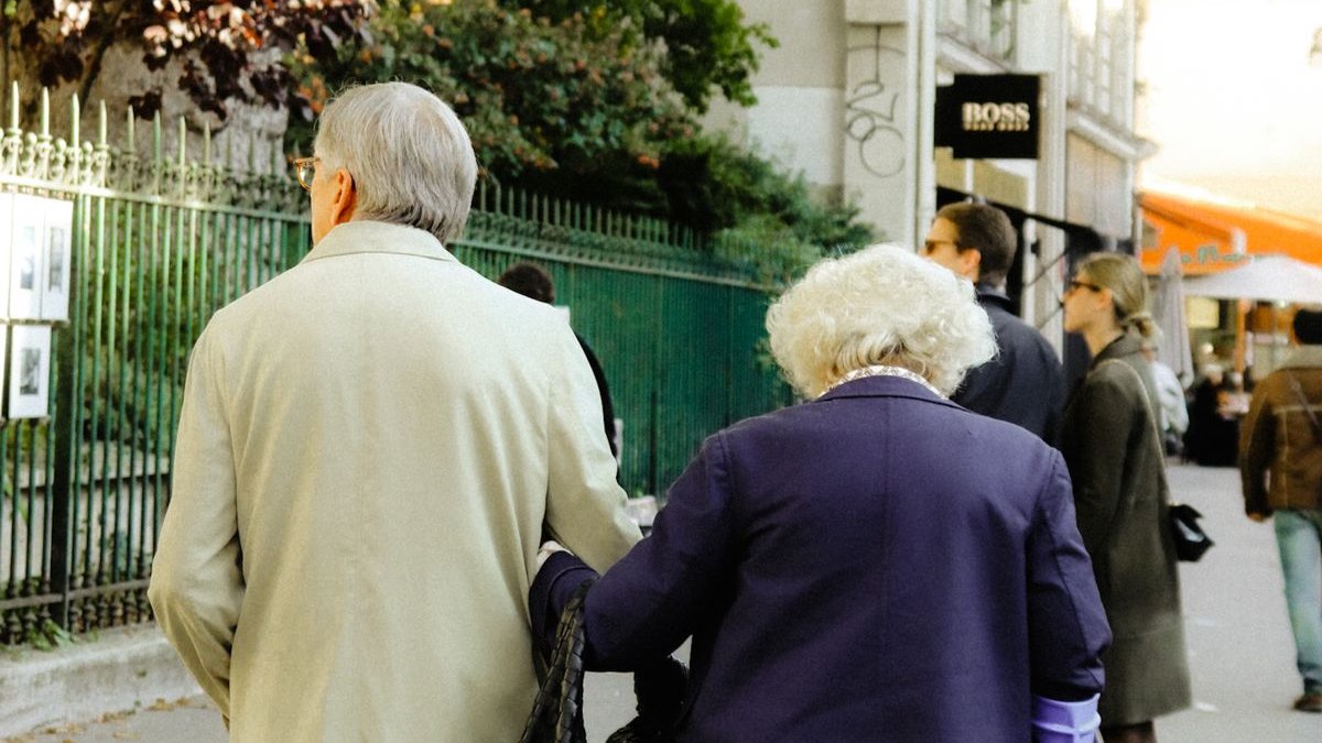 Älteres Paar spaziert Arm in Arm durch die Stadt