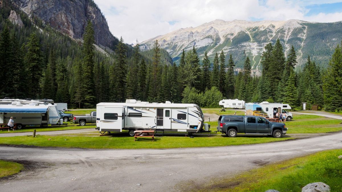 Campingplatz mit Wohnwagen vor Bergen