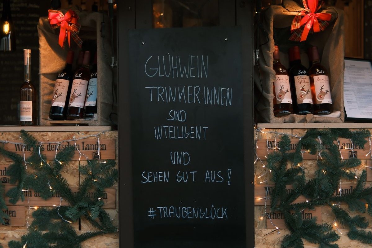 Glühweinstand mit Tafel und Tannenzweigen auf einem Weihnachtsmarkt