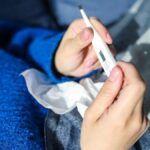 Person liest ein Fieberthermometer ab
