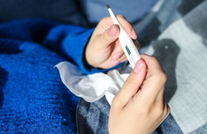 Person liest ein Fieberthermometer ab