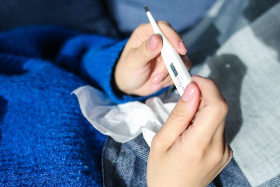 Person liest ein Fieberthermometer ab