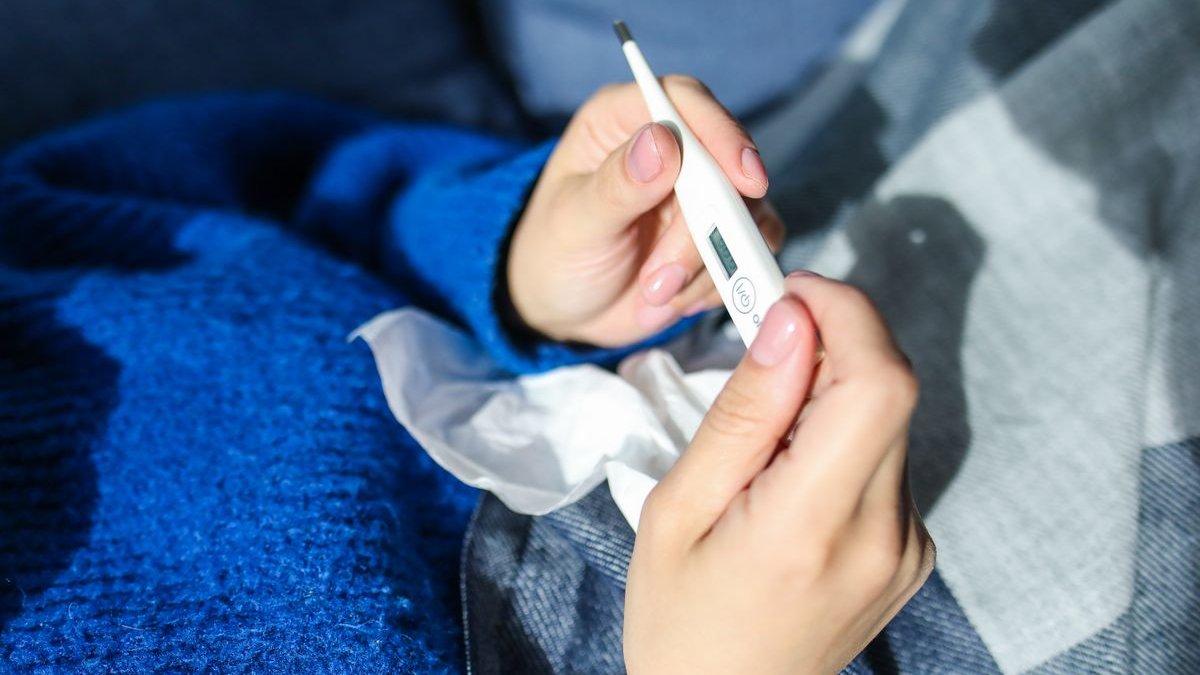Person liest ein Fieberthermometer ab