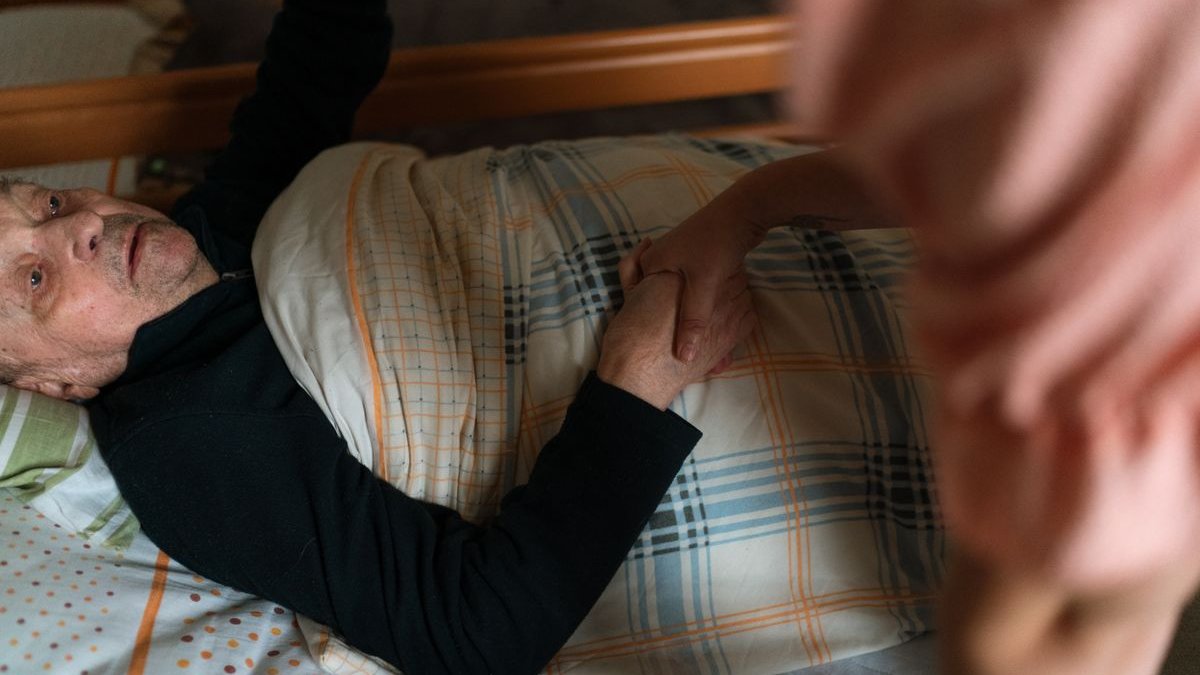 Pflegekraft unterstützt eine ältere Frau zu Hause