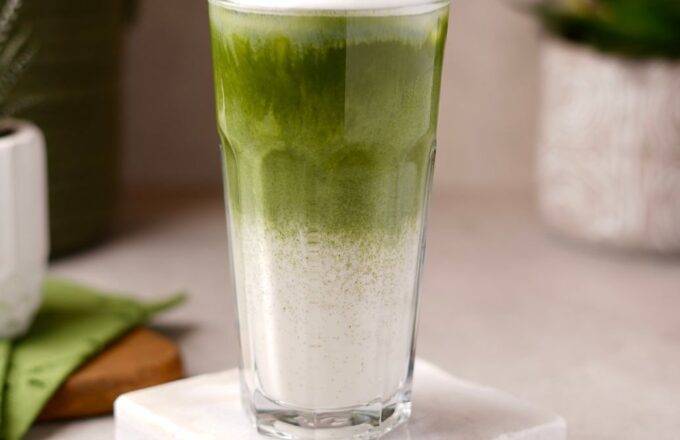 Iced Matcha Latte im Glas mit Bambusbesen