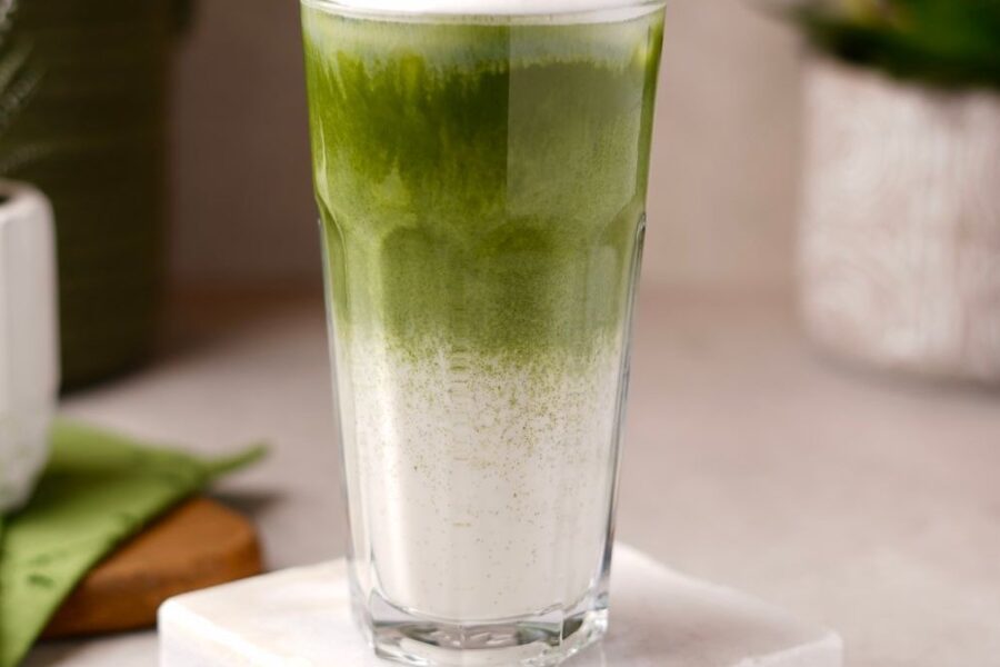 Iced Matcha Latte im Glas mit Bambusbesen