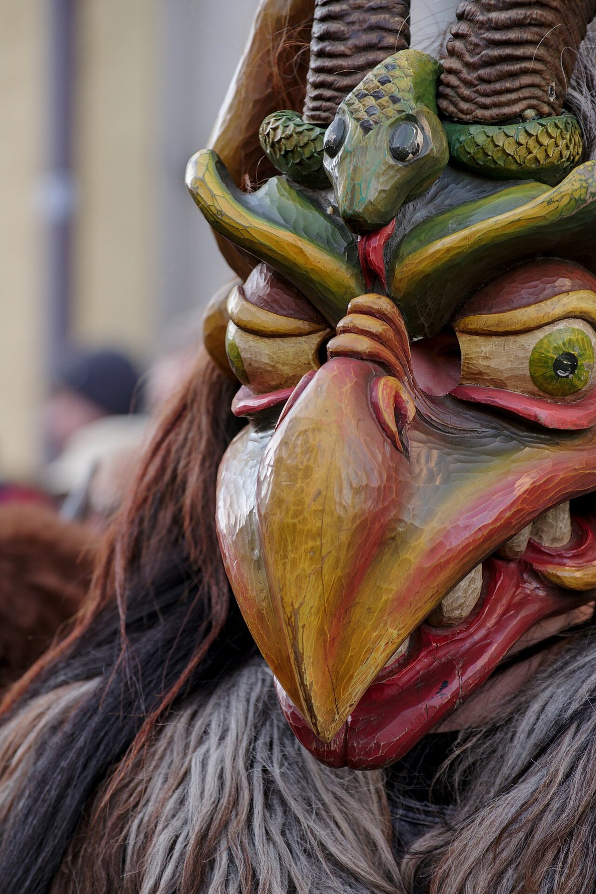 Geschnitzte Holzmaske einer Perchtengruppe mit Schnabel und Hörnern