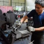 Mann arbeitet an einer Maschine in einer Werkstatt
