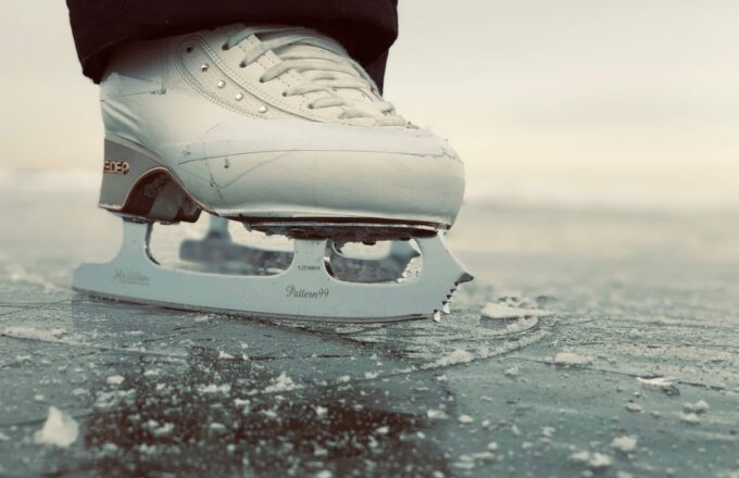 Schlittschuh mit Kufe auf glattem Eis in Nahaufnahme