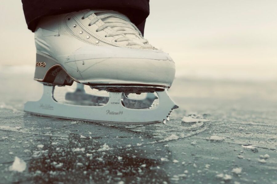 Schlittschuh mit Kufe auf glattem Eis in Nahaufnahme