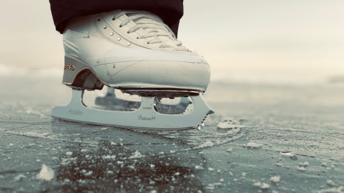 Schlittschuh mit Kufe auf glattem Eis in Nahaufnahme