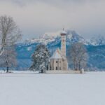 Verschneite Wallfahrtskirche St. Coloman vor den Allgäuer Alpen