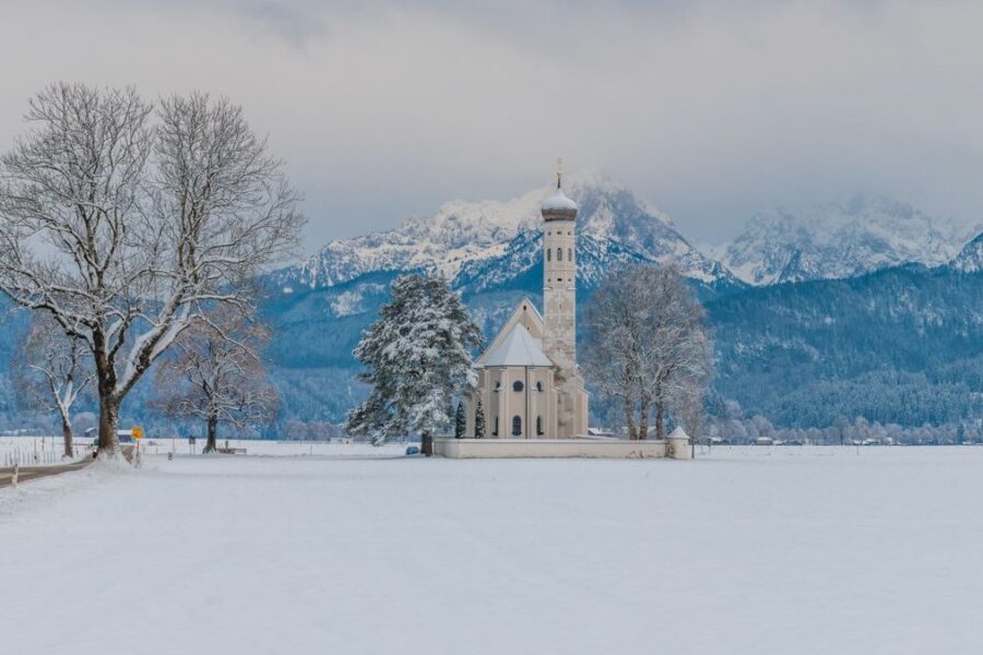 Verschneite Wallfahrtskirche St. Coloman vor den Allgäuer Alpen