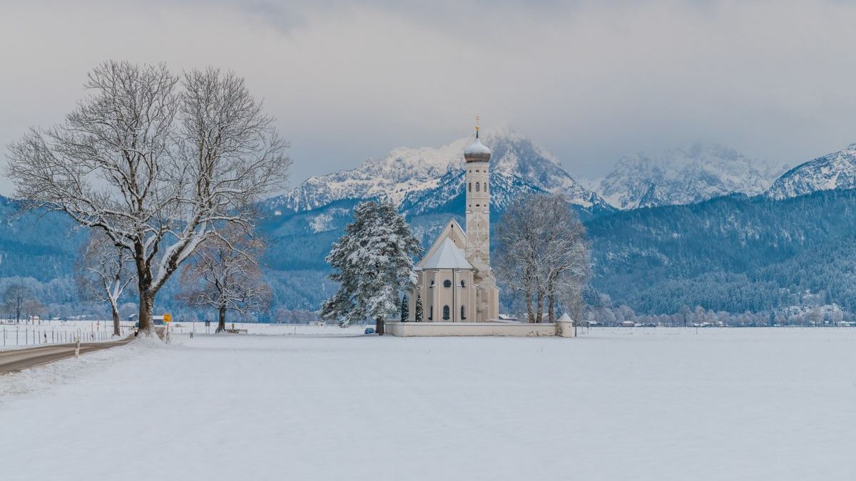 Verschneite Wallfahrtskirche St. Coloman vor den Allgäuer Alpen