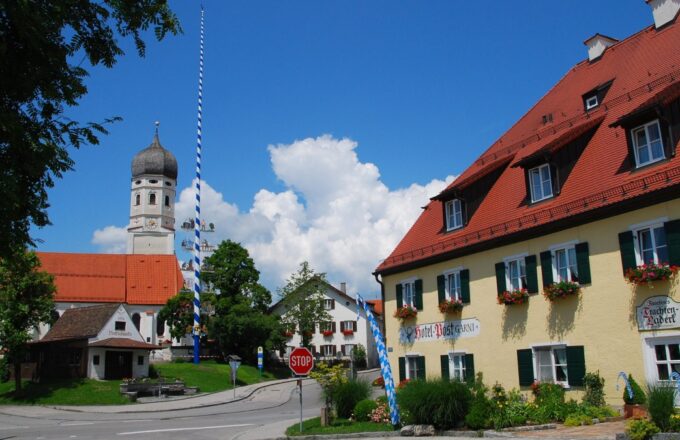 Ehemaliger Gasthof zur Post mit Kirche und Maibaum in Erling bei Andechs